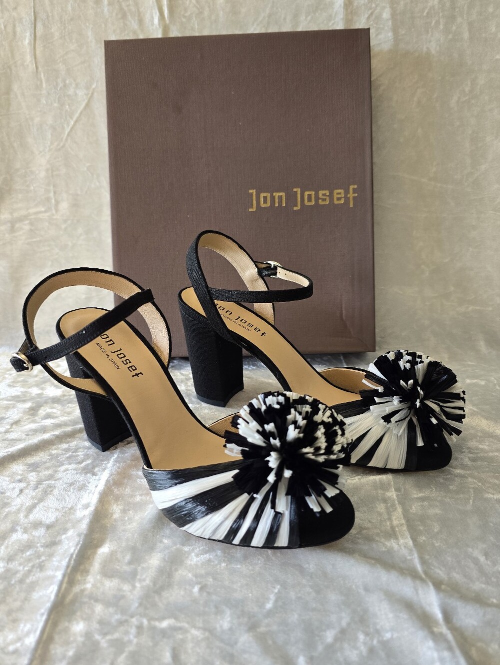 Jon Josef Nest Heels featuring a chunky block heel and a playful raffia pom-pom